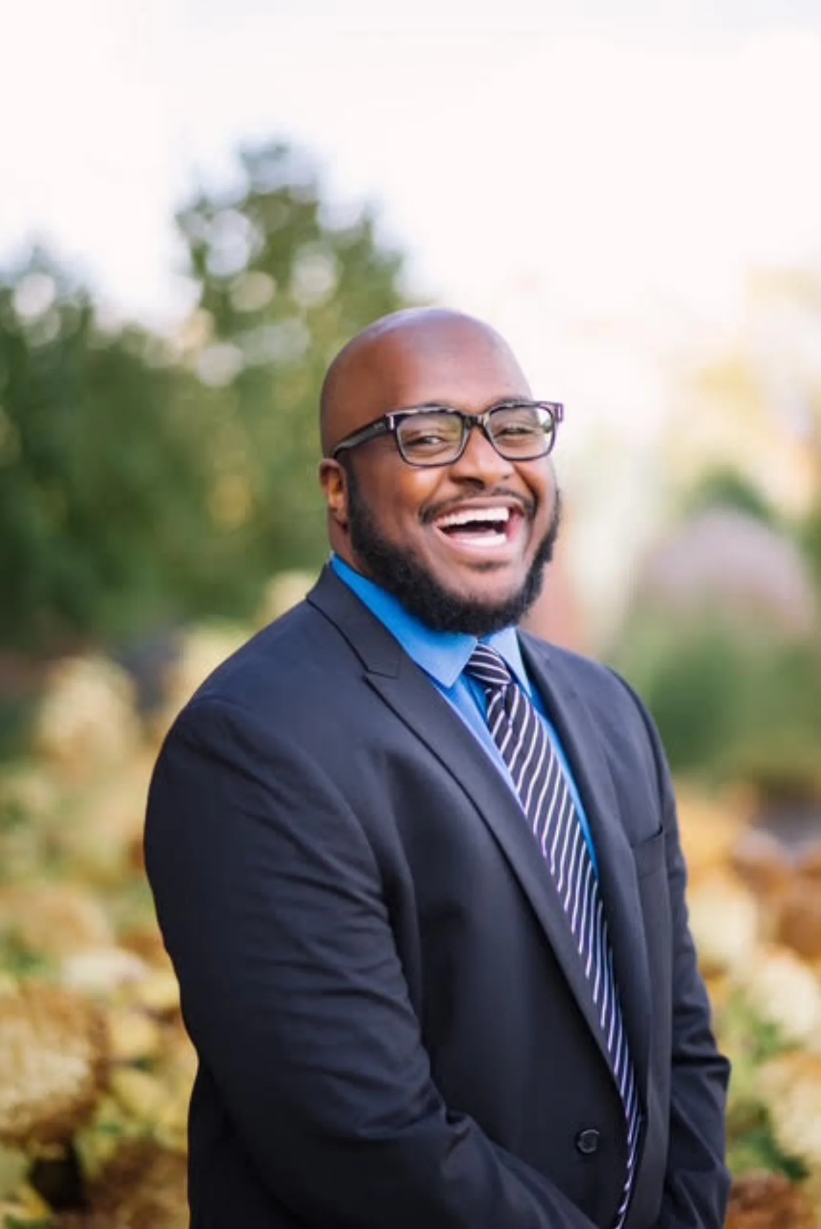 Dr. Alton Johnson laughing in an autumn garden
